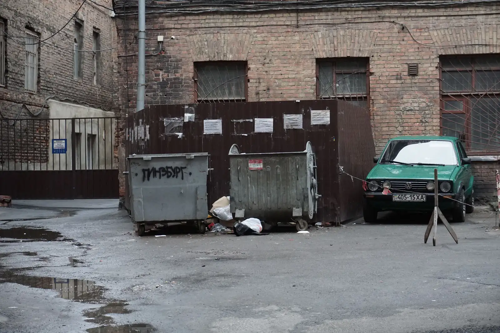 Metal waste containers in a brick courtyard